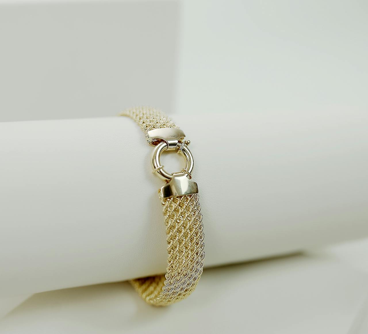 Luxurious gold bracelet with a stylish design on a white surface.