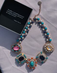 Colorful gemstone necklace with beads elegantly displayed beside a quote box.